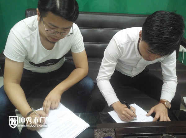 重庆坤秀木门 田总（左）和红星美凯龙代表签约